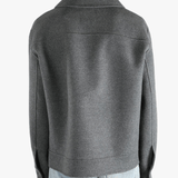 Grey jacket worn by a person, showing the pants fit