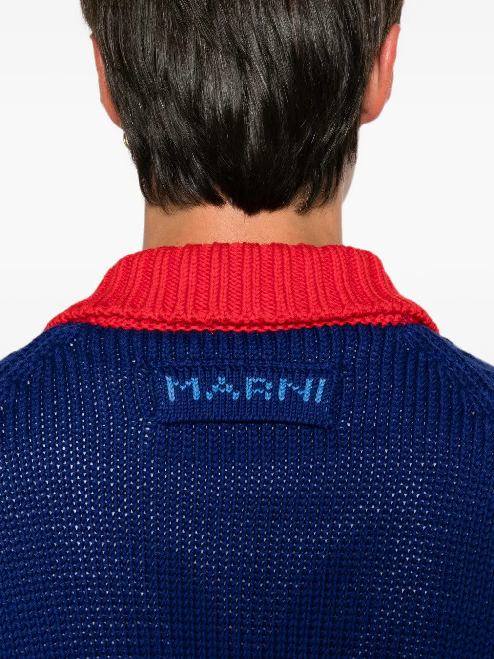 Blue knitwear worn by a person, showing the knitwear fit