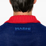 Blue knitwear worn by a person, showing the knitwear fit