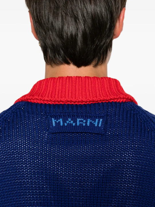 Blue knitwear worn by a person, showing the knitwear fit