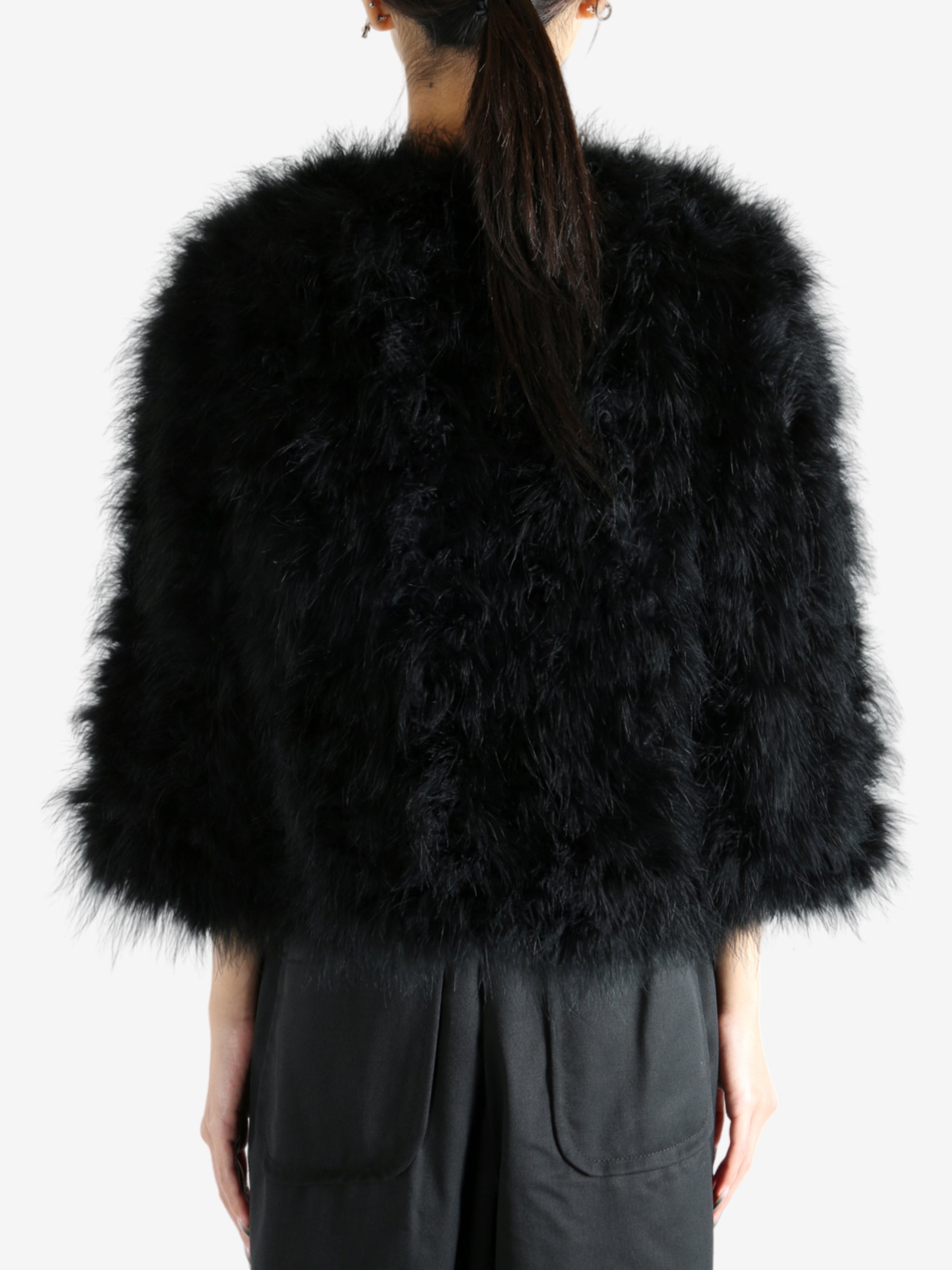 Black coat worn by a person, showing the coat's fit