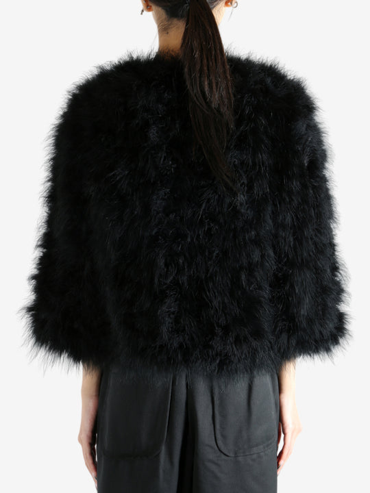 Black coat worn by a person, showing the coat's fit