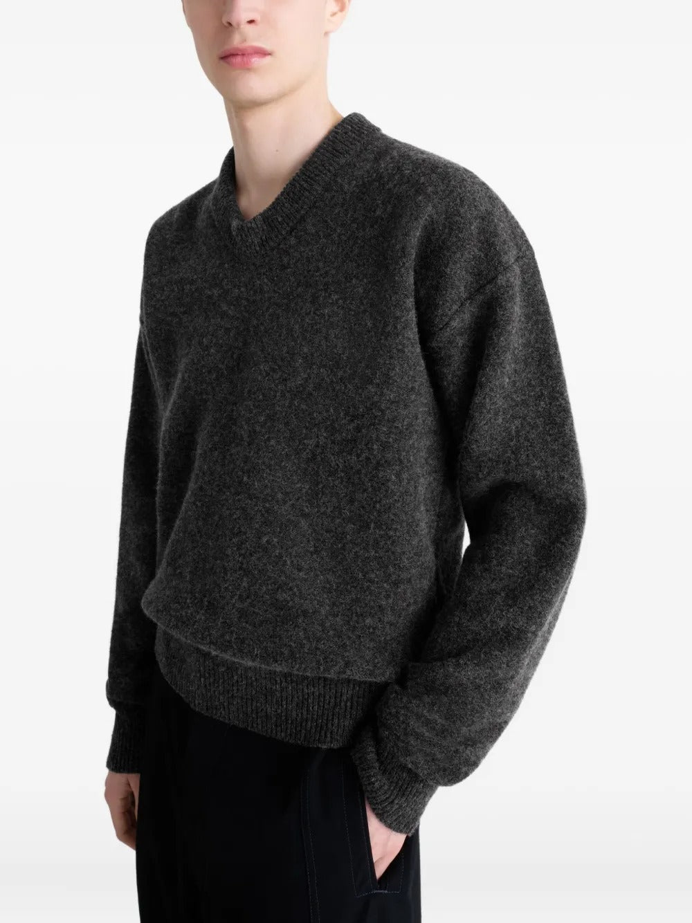 Black sweater worn by a person, showing the sweater's fit