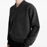Black sweater worn by a person, showing the sweater's fit