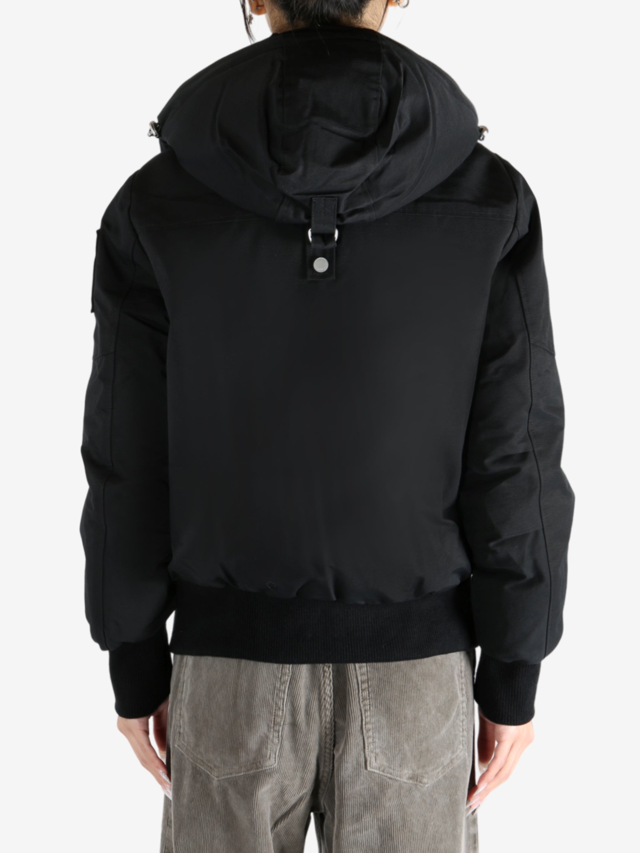 Black coat worn by a person, showing the coat fit