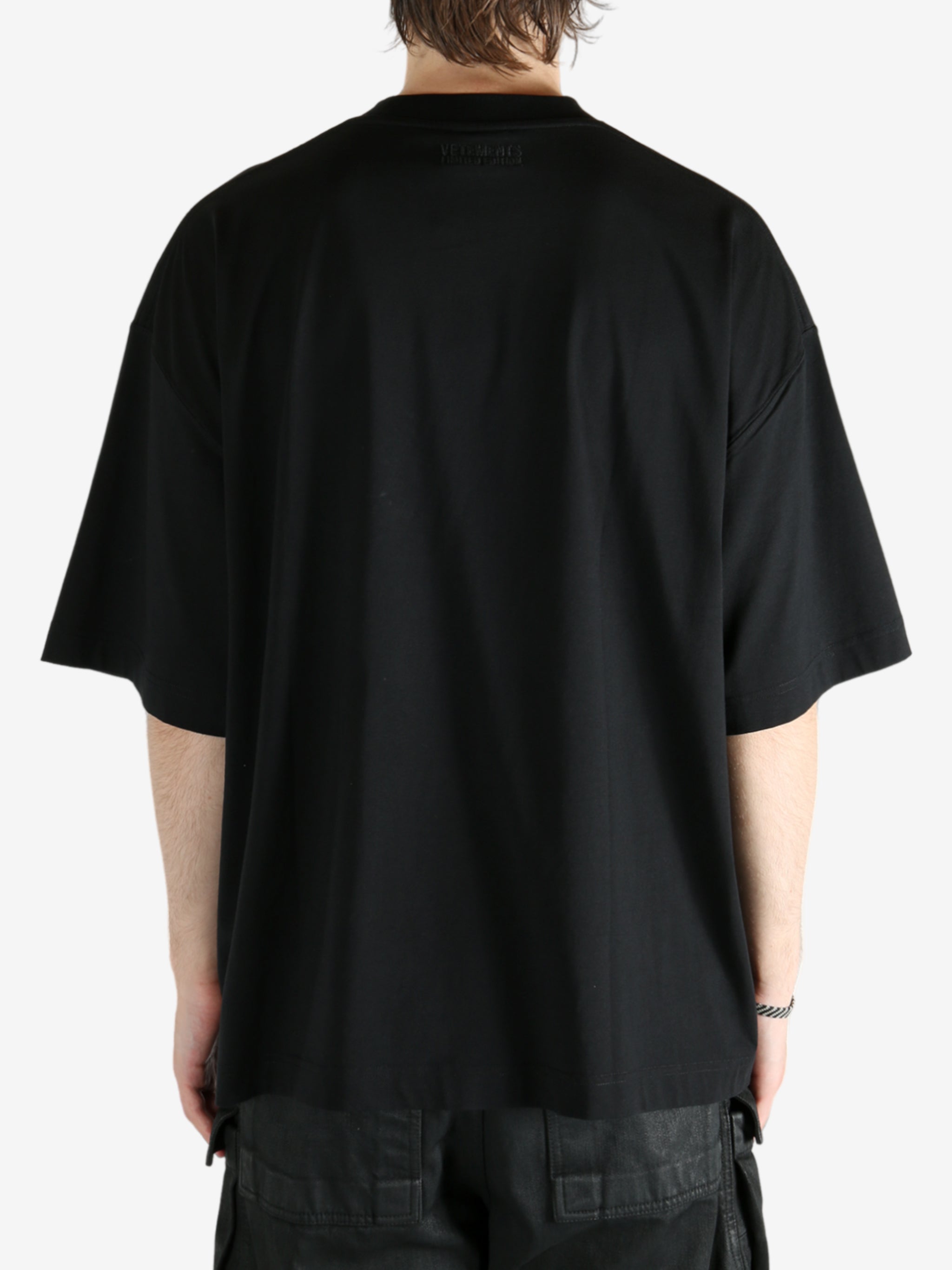 Black t-shirt worn by a person, showing the shirt's fit
