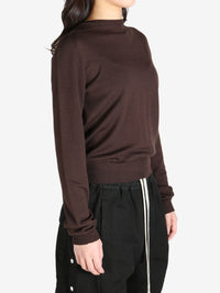 Brown sweater worn by a person, side view