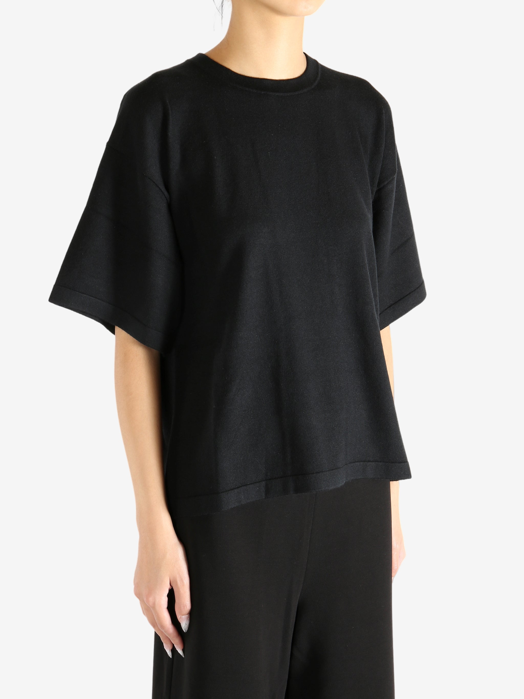 Black t-shirt worn by a person, showing the shirt's fit