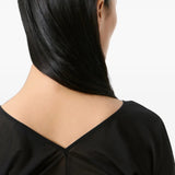 Black top worn by a person, showing the top fit