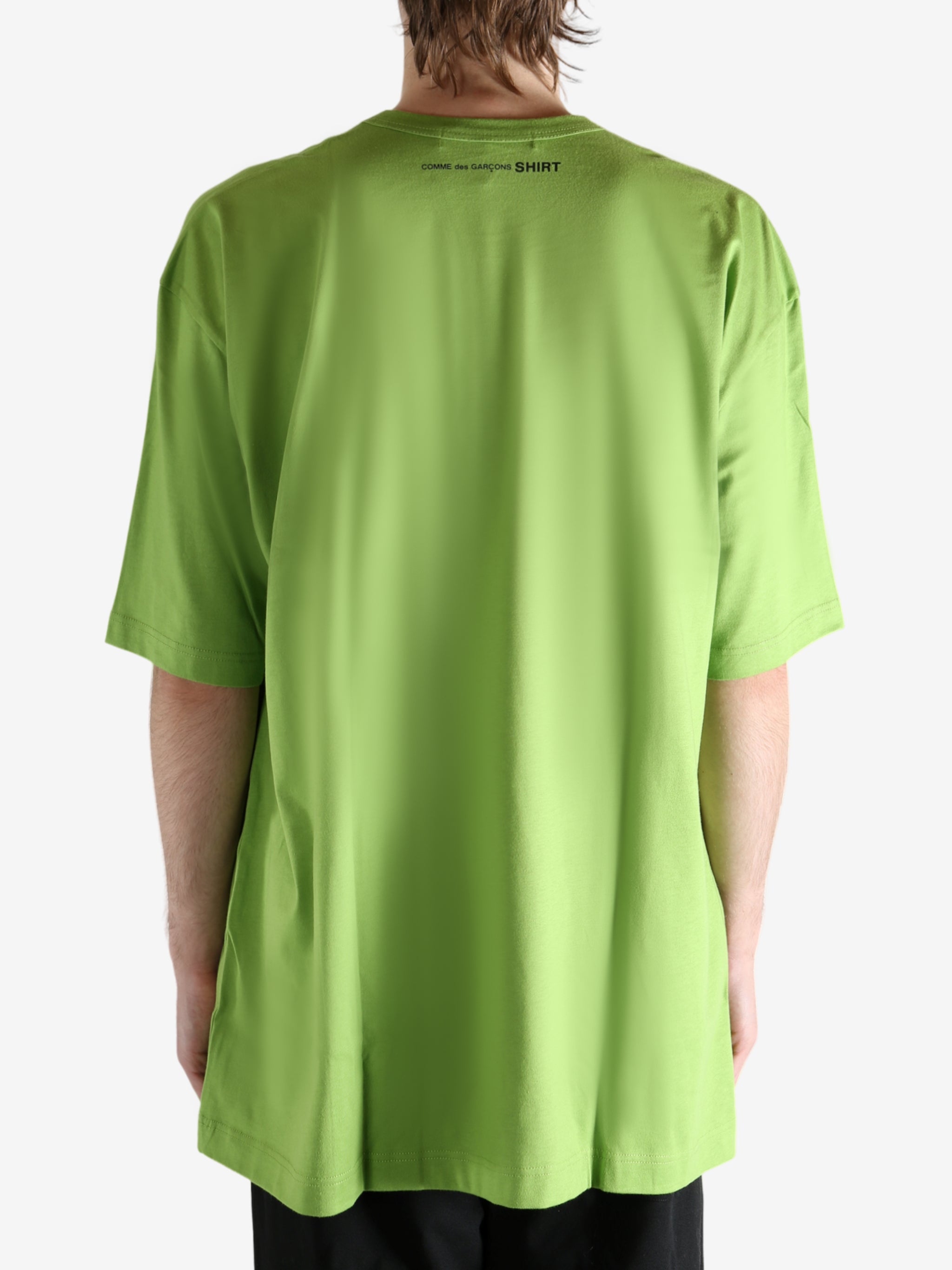 Green t-shirt worn by a person, showing the shirt's fit