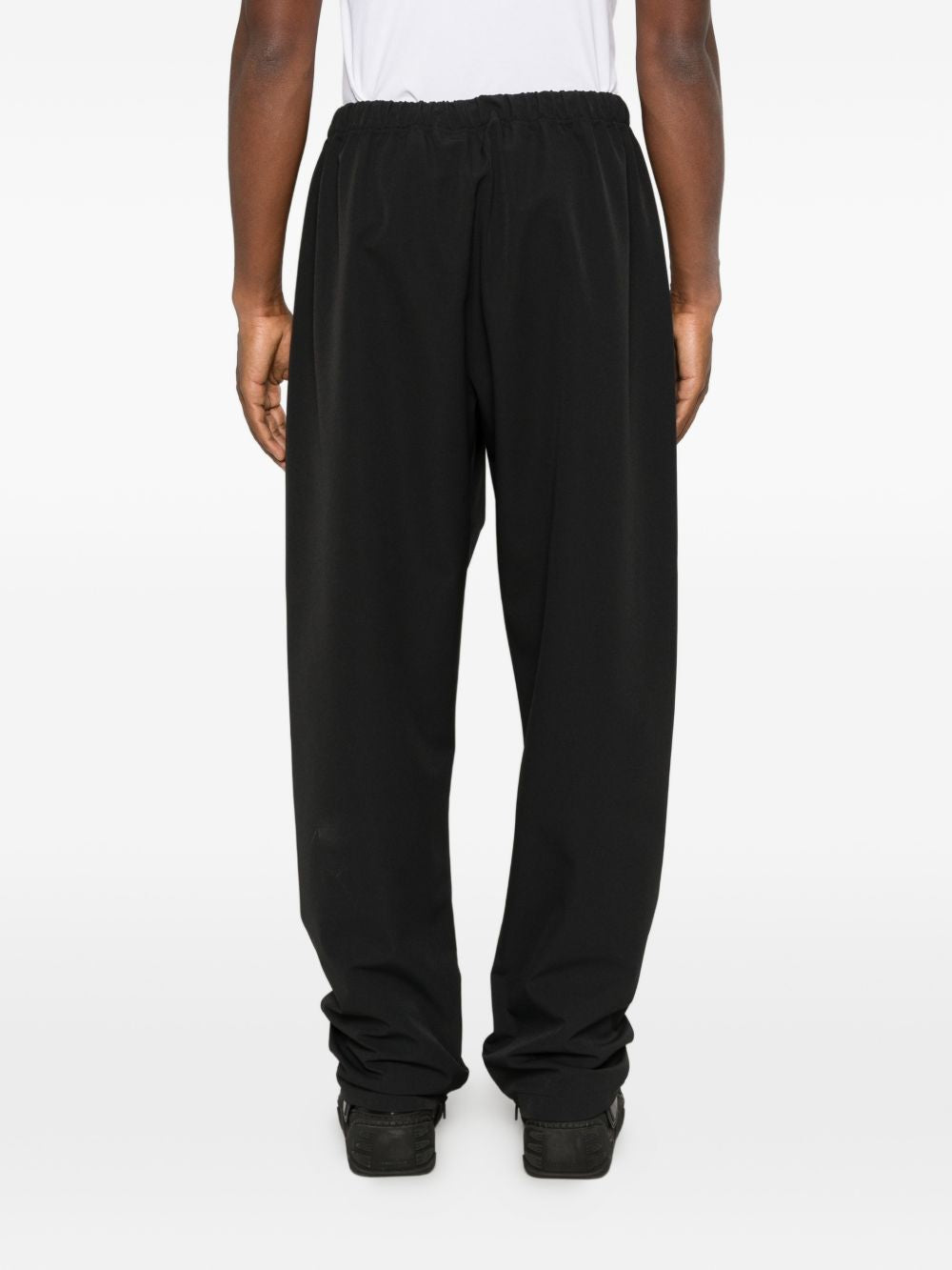 Black pants worn by a person, showing the pants' fit