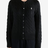 Black knitwear worn by a person, showing the knitwear fit