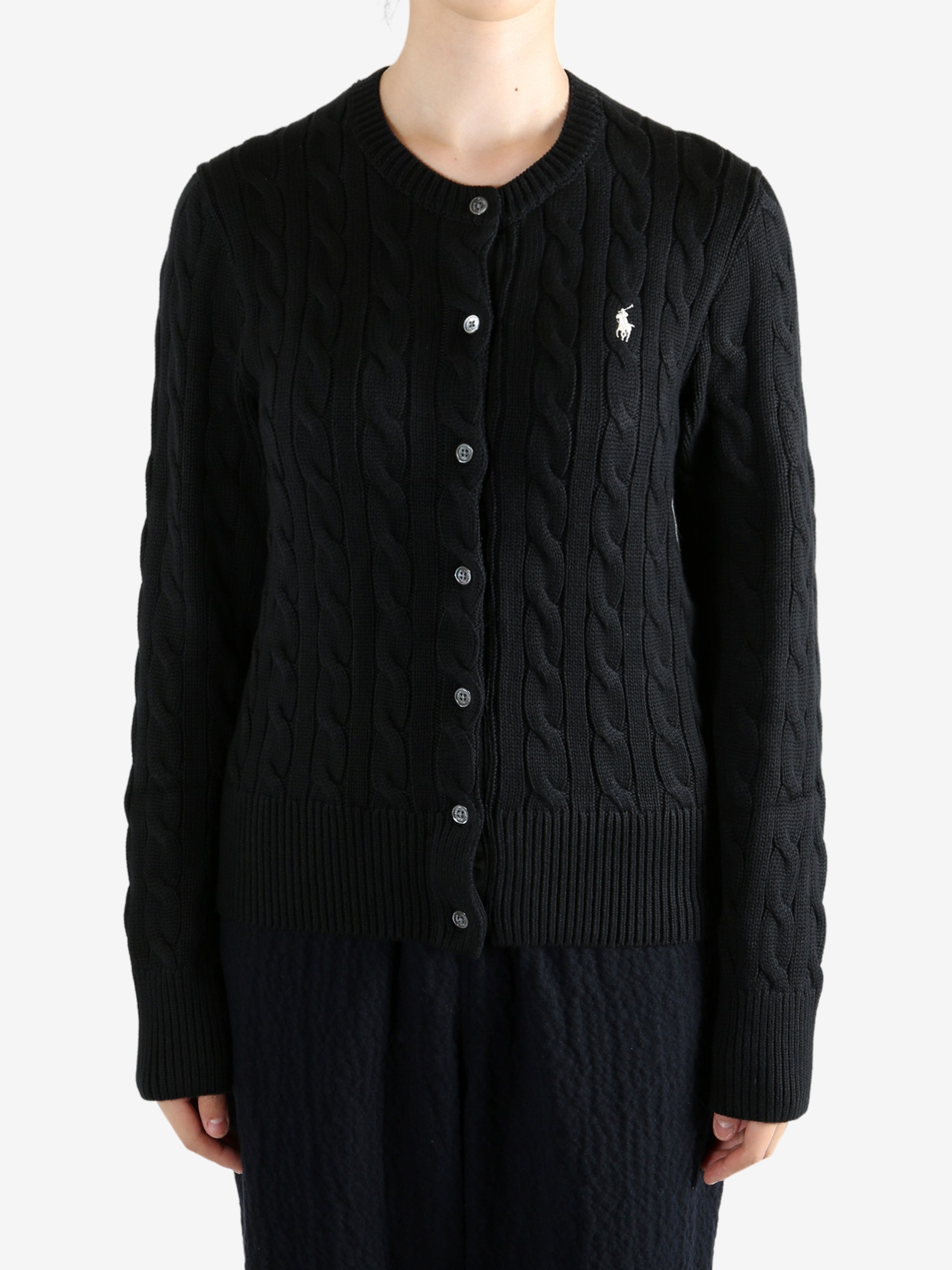 Black knitwear worn by a person, showing the knitwear fit