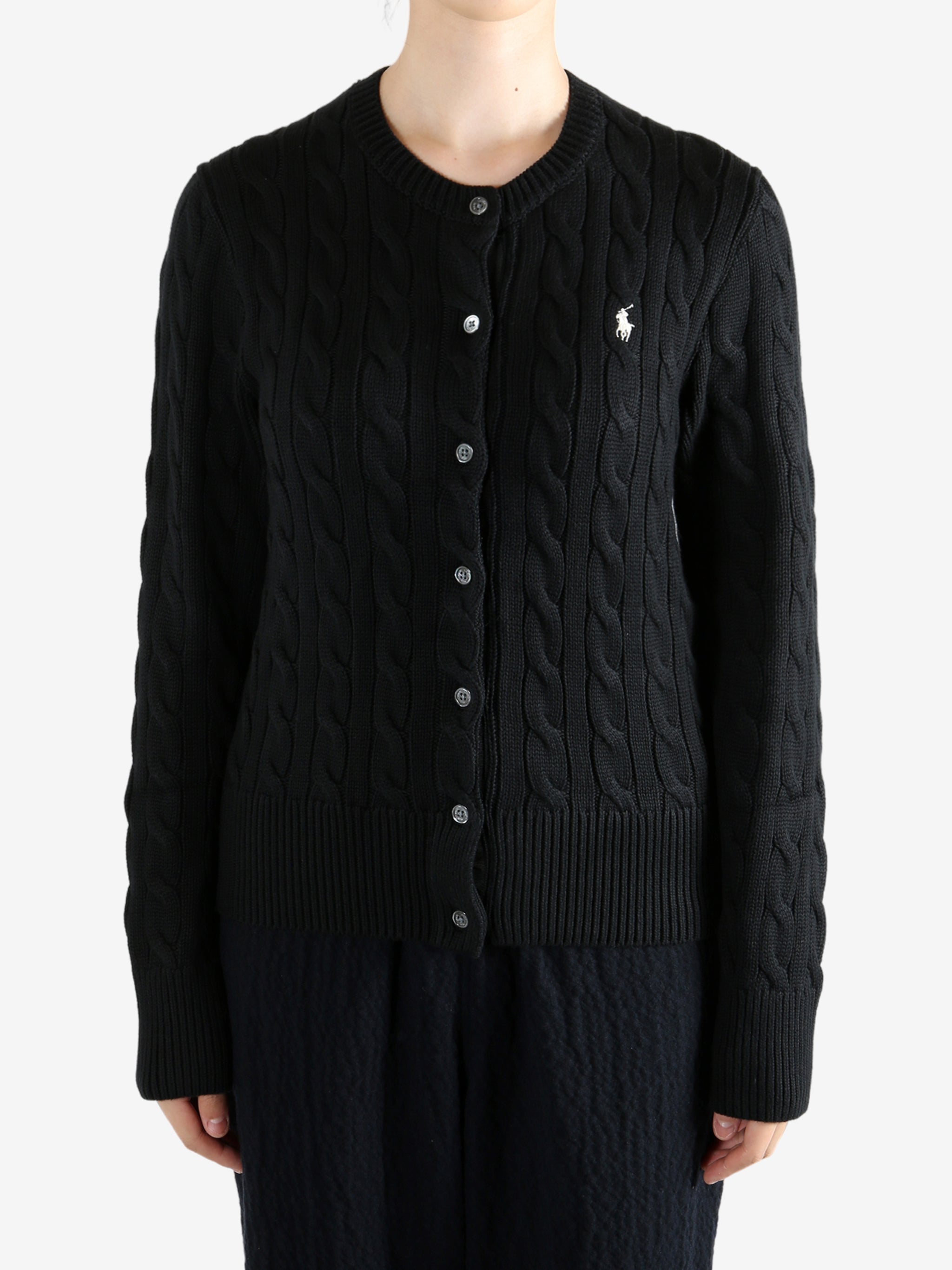 Black knitwear worn by a person, showing the knitwear fit