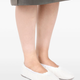 white sneakers worn by a person, showing the sneakers  fit