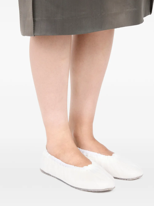 white sneakers worn by a person, showing the sneakers  fit