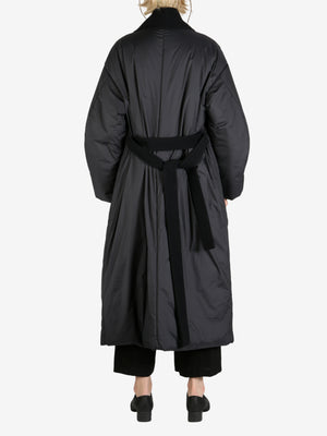 Black coat worn by a person, showing the coat fit
