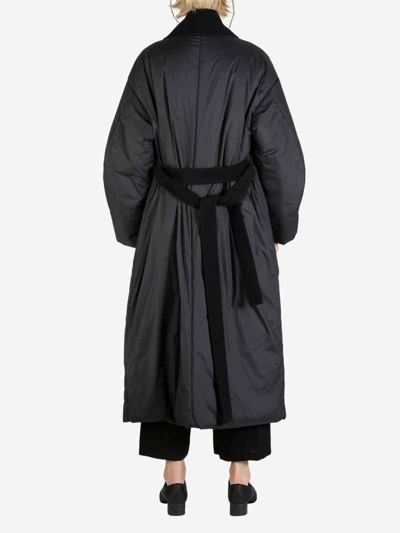 Black coat worn by a person, showing the coat fit