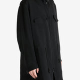 Black coat worn by a person, showing the coat fit