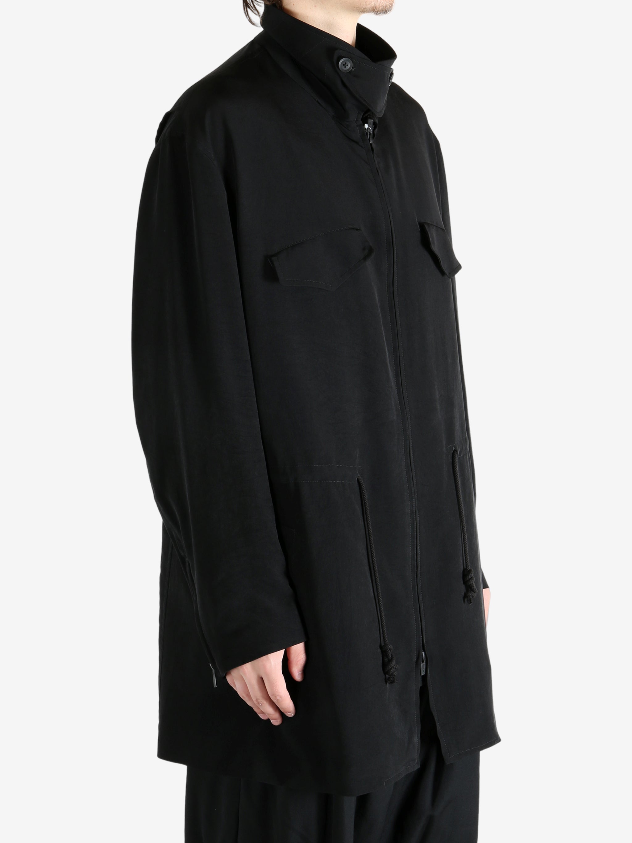 Black coat worn by a person, showing the coat fit