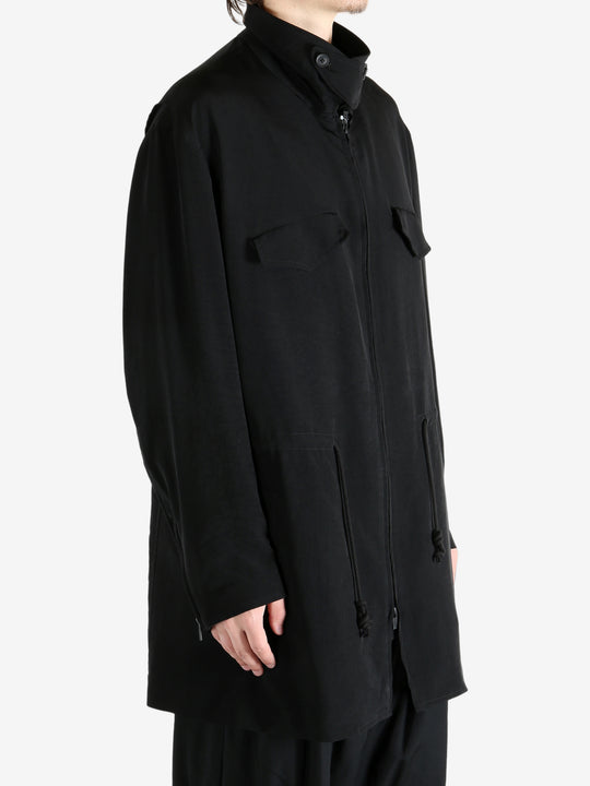 Black coat worn by a person, showing the coat fit