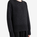 Grey knitwear worn by a person, showing the knitwear fit