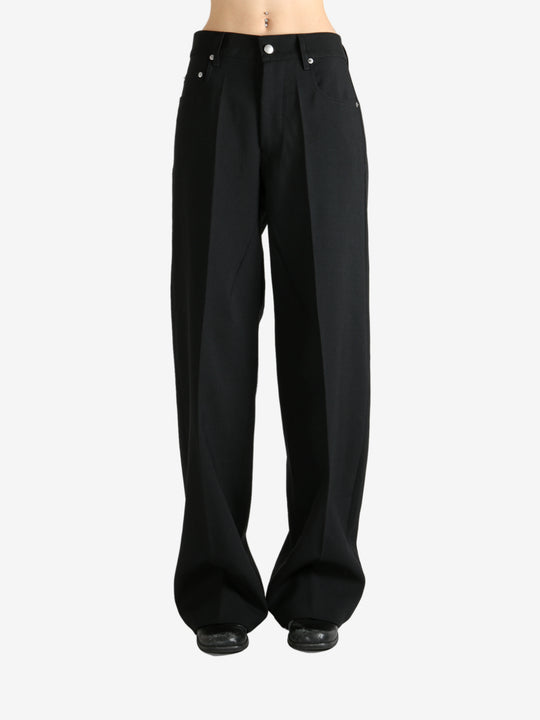 Black pants worn by a person, showing the pants fit