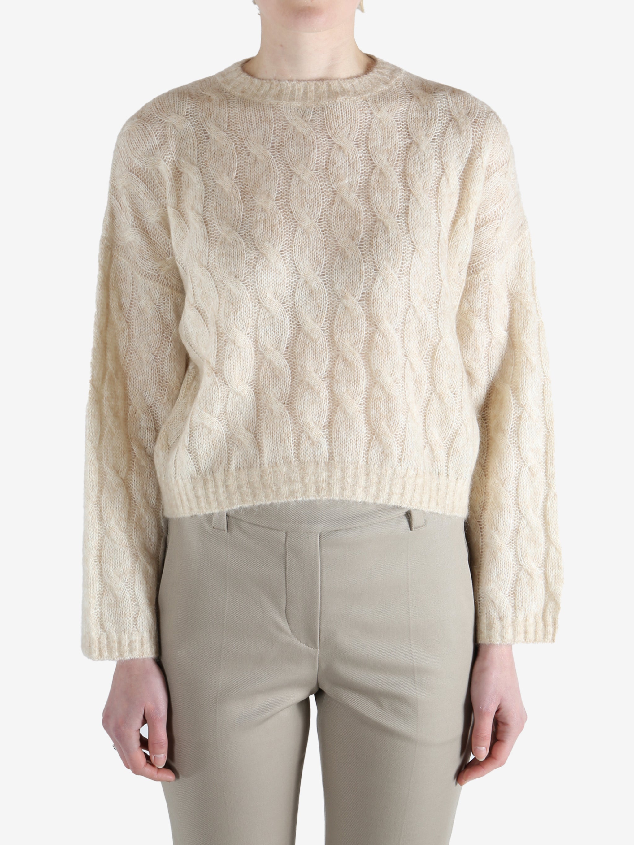 beige cable knit sweater worn by a person, showing the sweater fit