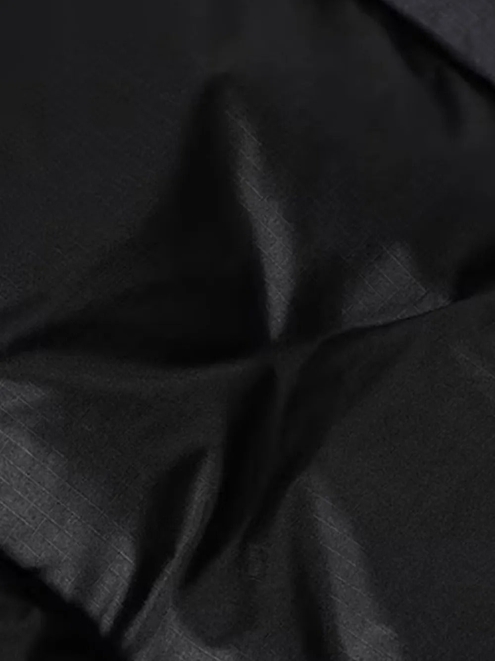 Close up of black jacket, showing texture of the nylon fabric