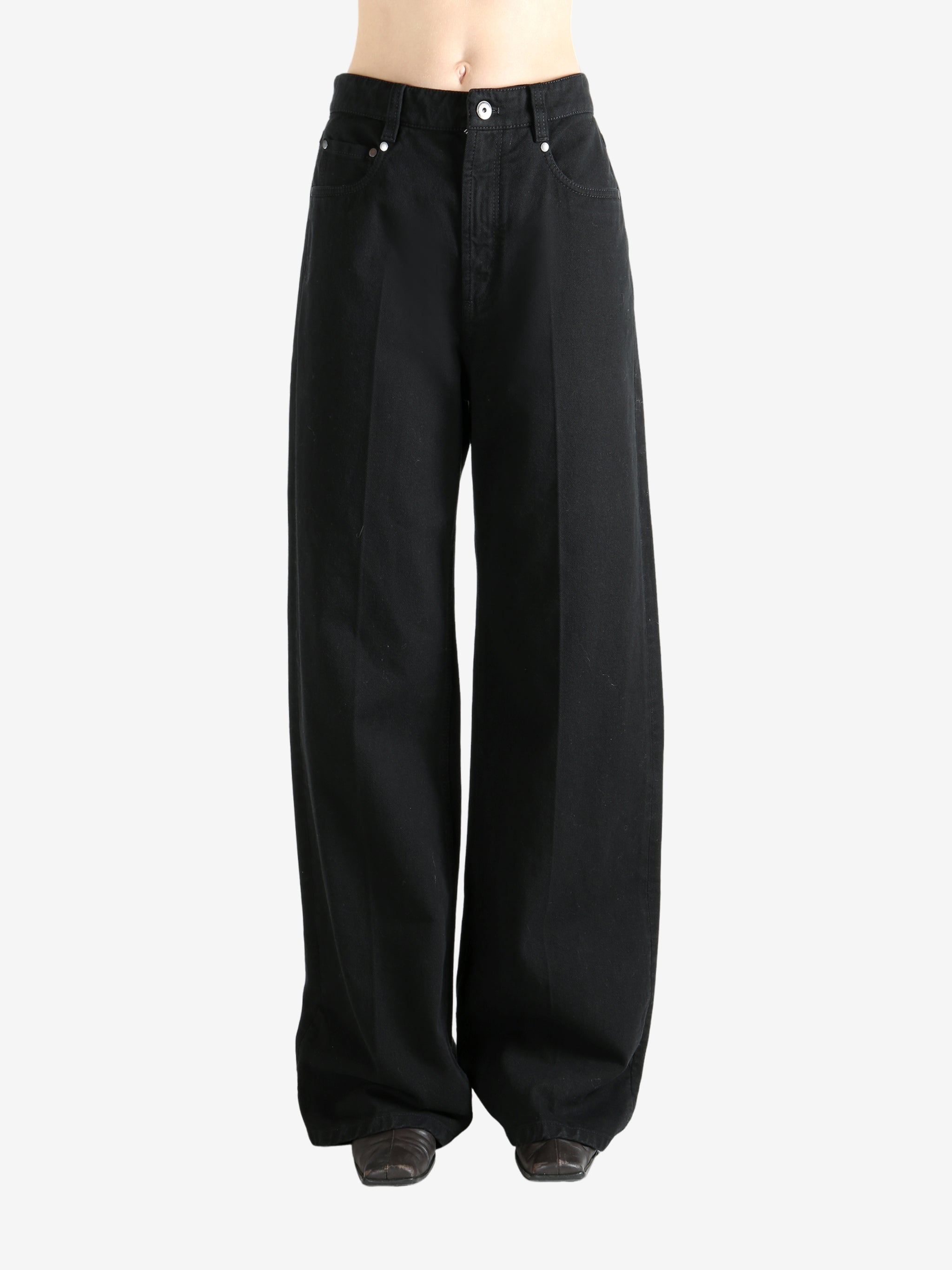 Black pants worn by a person, showing the pant's fit