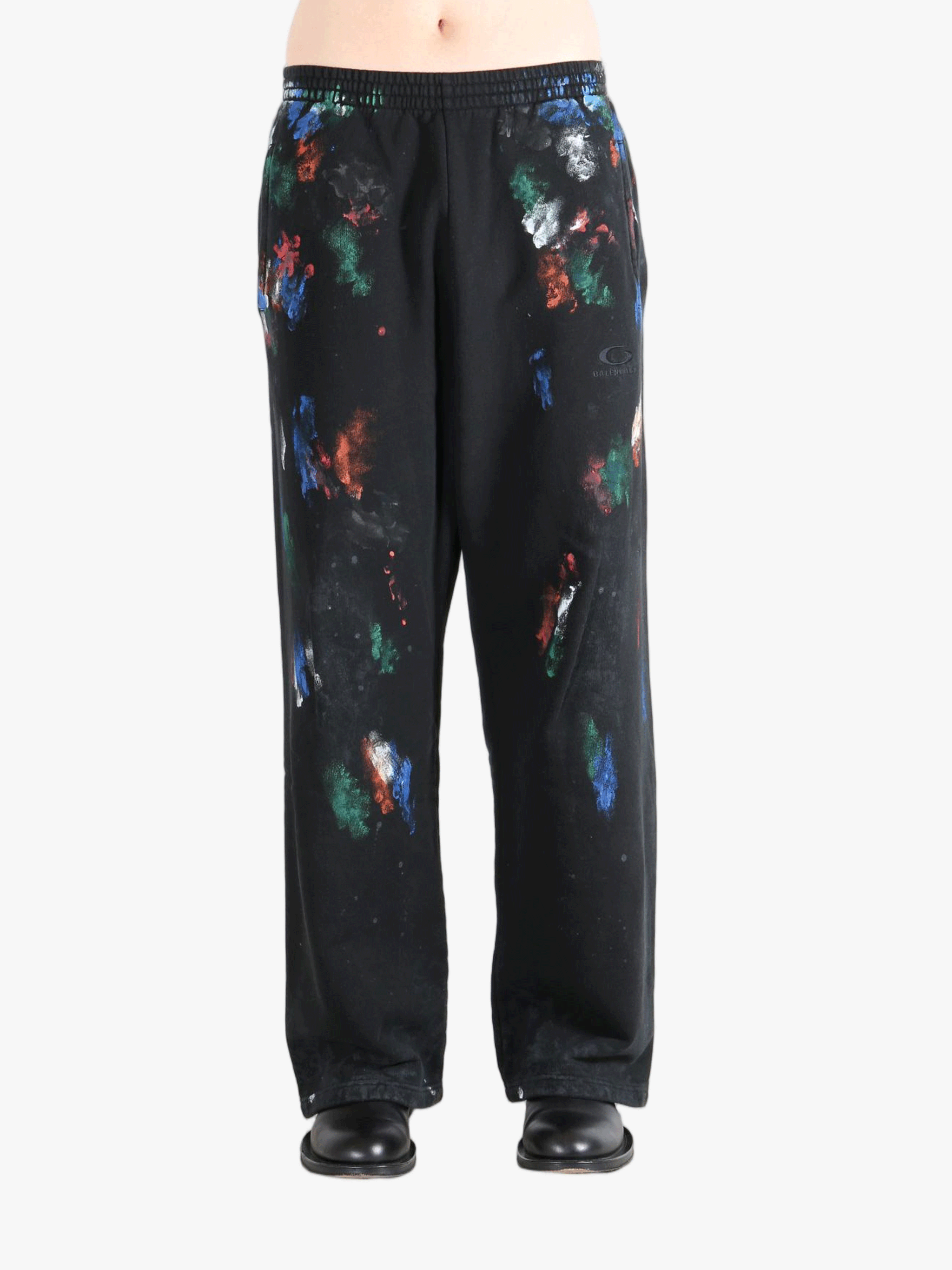 Black pants worn by a person, showing the shirt's fit