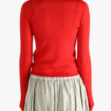 Red knitwear worn by a person, showing the knitwear's fit