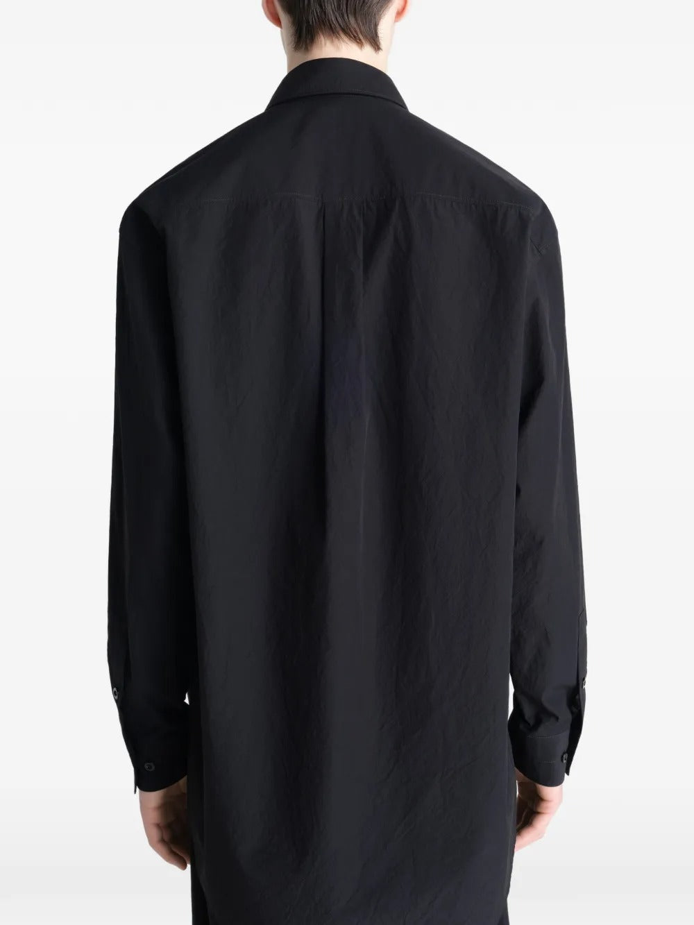 Black shirt worn by a person, showing the shirt's fit