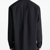 Black shirt worn by a person, showing the shirt's fit