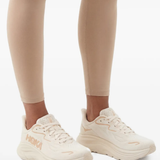 White sneakers worn by a person, showing the sneakers' fit