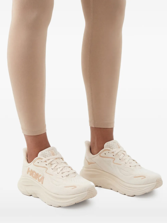 White sneakers worn by a person, showing the sneakers' fit
