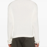 White knitwear worn by a person, showing the knitwear fit