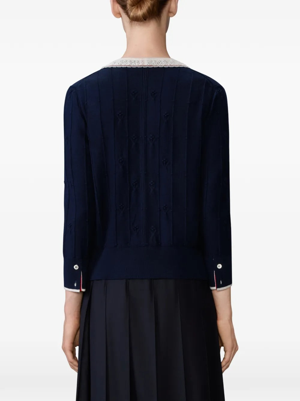 Navy knitwear worn by a person, showing the knitwear's fit