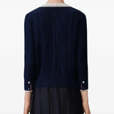 Navy knitwear worn by a person, showing the knitwear's fit