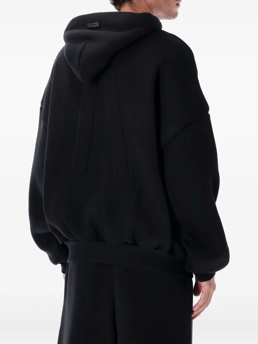 Black hoodie worn by a person, showing the hoodie's fit
