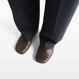 Brown heels worn by a person, showing the heels' fit