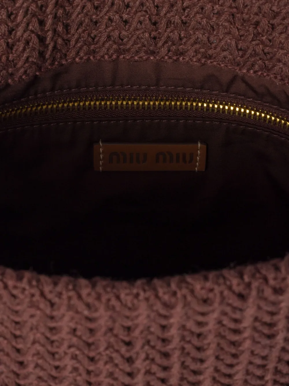 Close up of brown bag, showing the detial of inside pocket and logo patch
