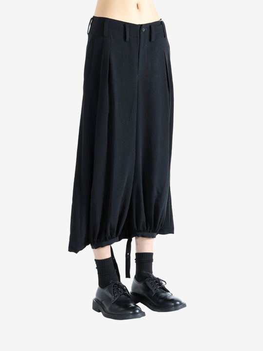 Black pants worn by a person, showing the pants' fit