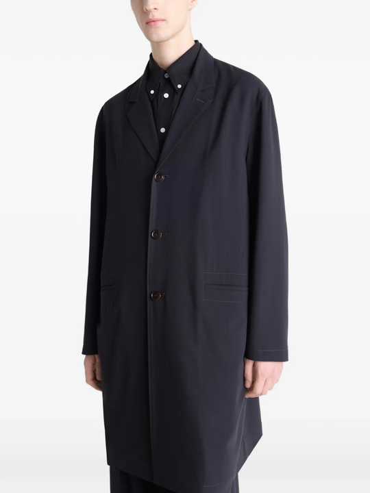 Black coats worn by a person, showing the coats fit