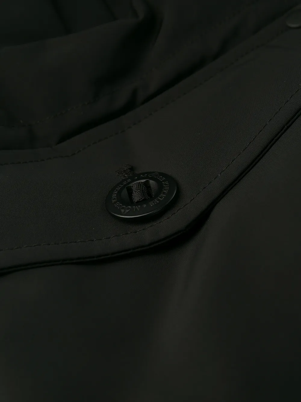 Close up of black jackets, showing texture of the nylon and polyester and feather down fabric