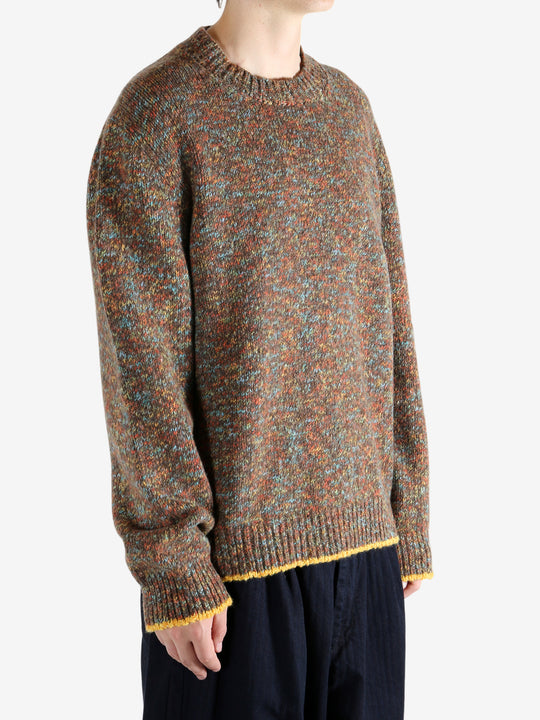 Brown knitwear worn by a person, showing the knitwear's fit