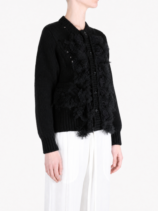 Black knitwear worn by a person, showing the knitwear fit