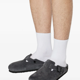 Black clog shoe worn by a person, showing the shoes fit