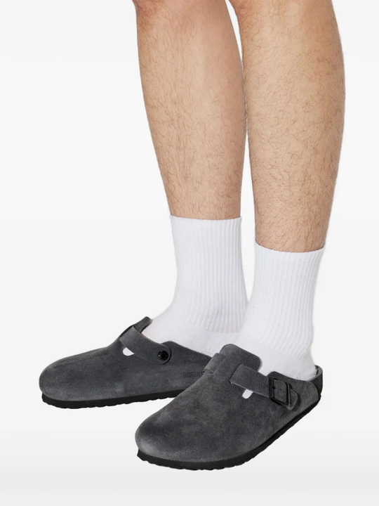 Black clog shoe worn by a person, showing the shoes fit