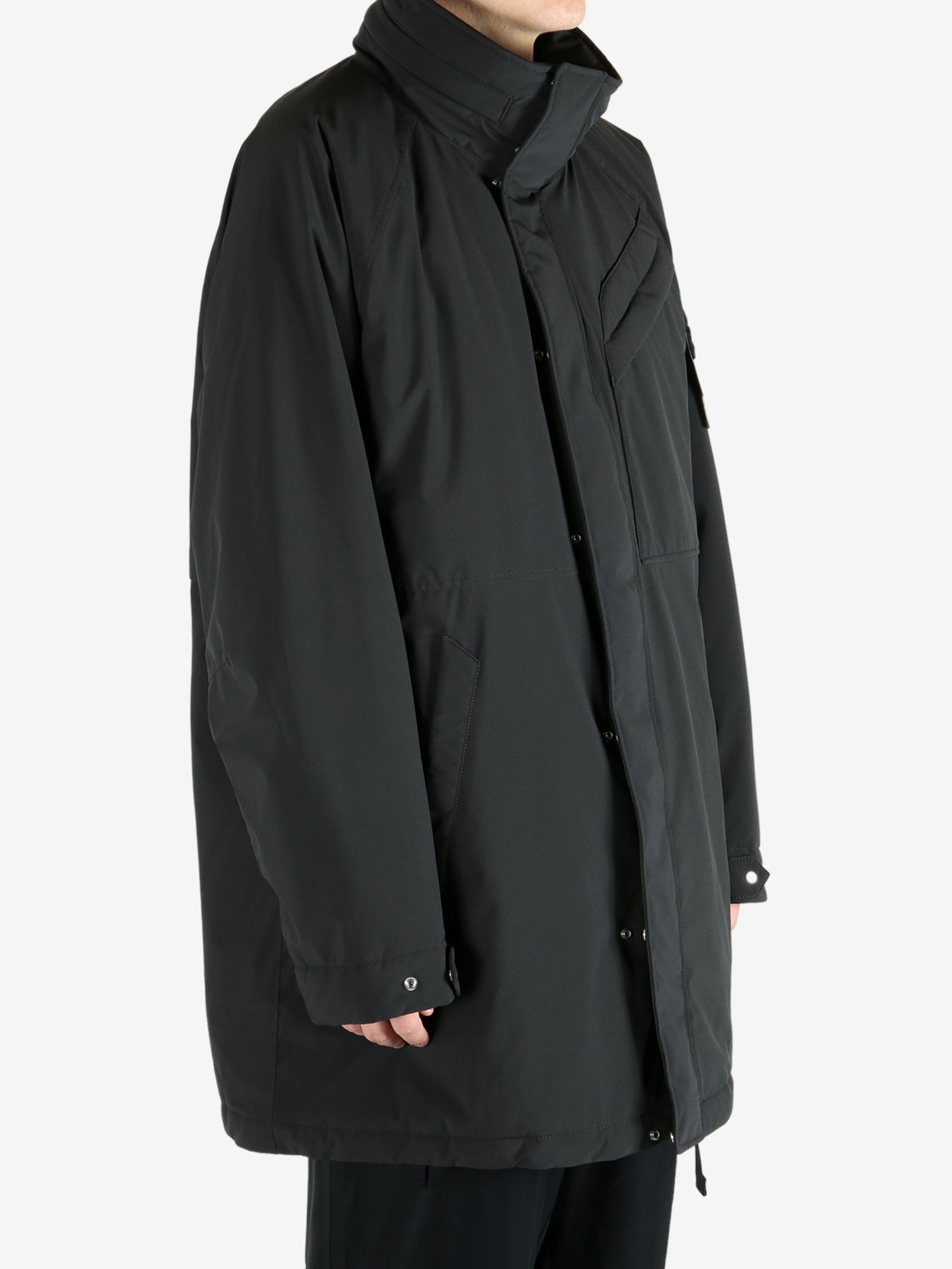 Black coat worn by a person, showing the coat fit